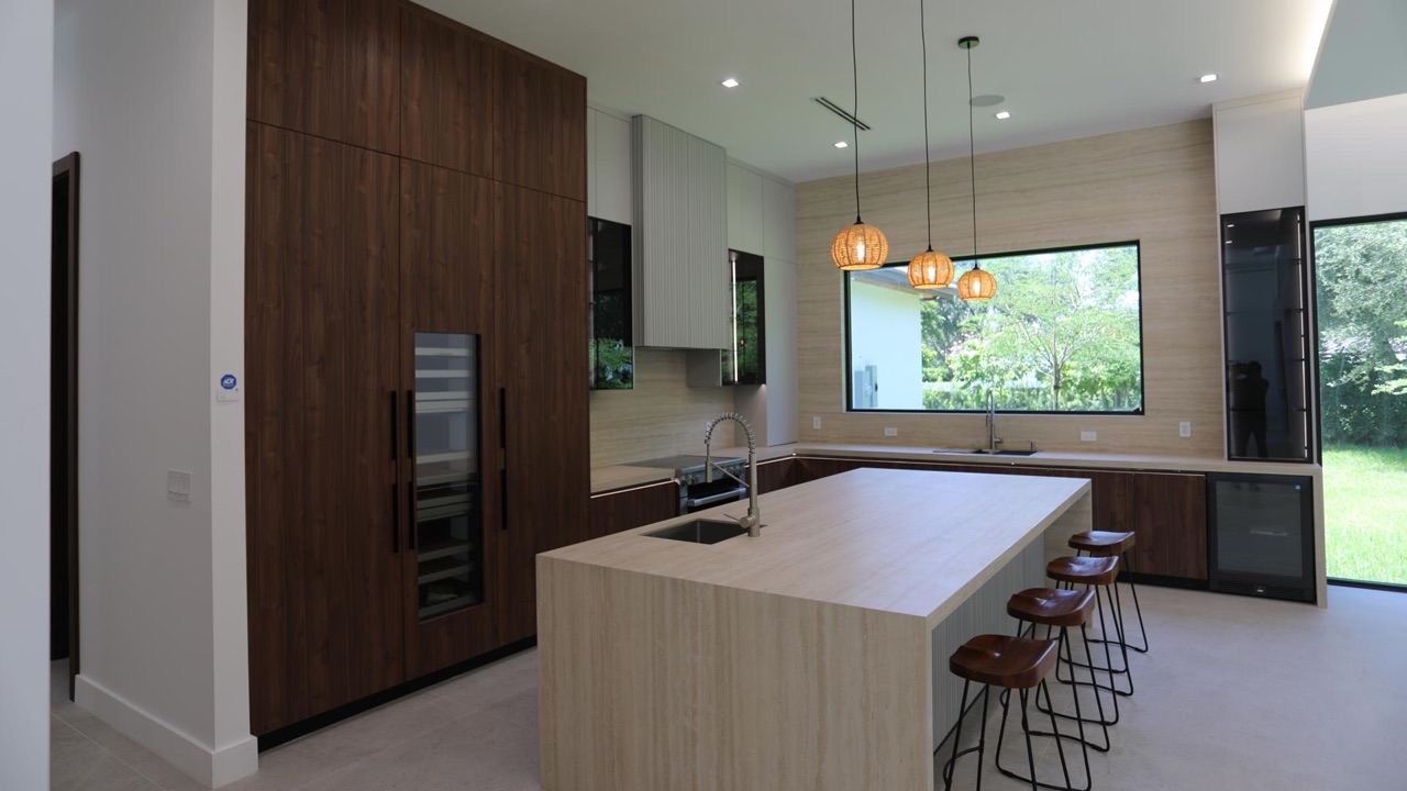 Custom kitchen bar area with a glass-front display cabinet, floating stone shelves and an integrated coffee station.