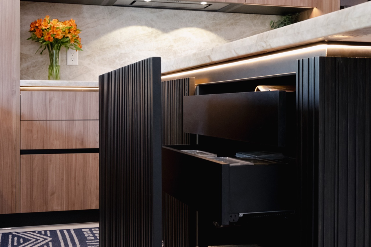 Custom concealed pantry storage integrated into wood kitchen cabinetry.