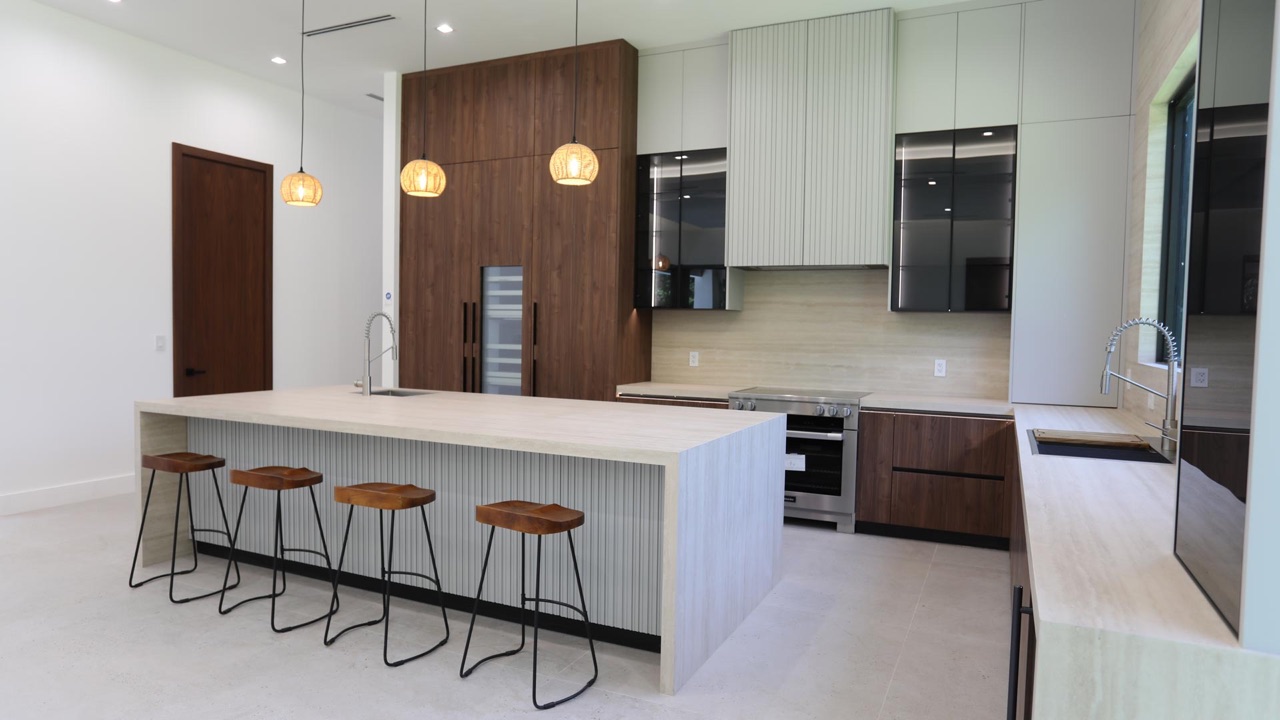 Large custom kitchen island with seating and open circulation.