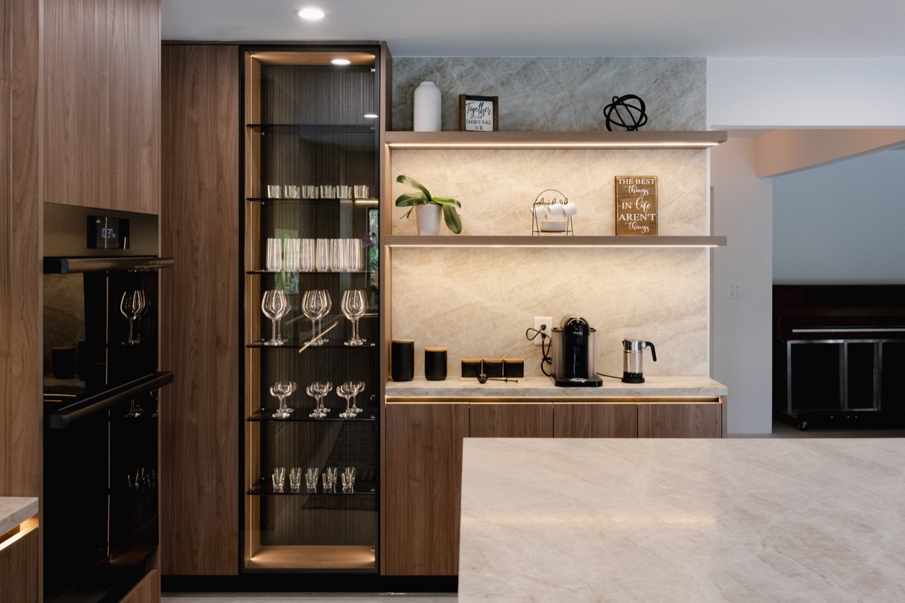 Modern wood and neutral custom cabinetry with integrated appliances and stone backsplash.