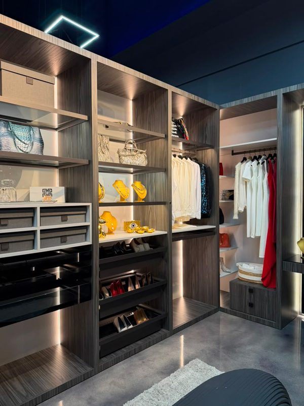 Small closet with shallow drawers and open shelves, pull-out shoe trays, and integrated LED lighting