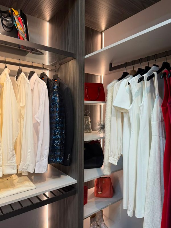 Floor-to-ceiling storage in a narrow closet, with LED-lit shelves and separate zones for shirts and dresses