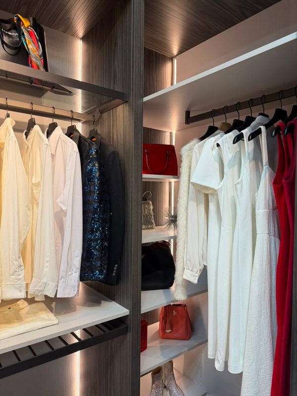 Floor-to-ceiling storage in a narrow closet with separate hanging zones for shirts and long garments