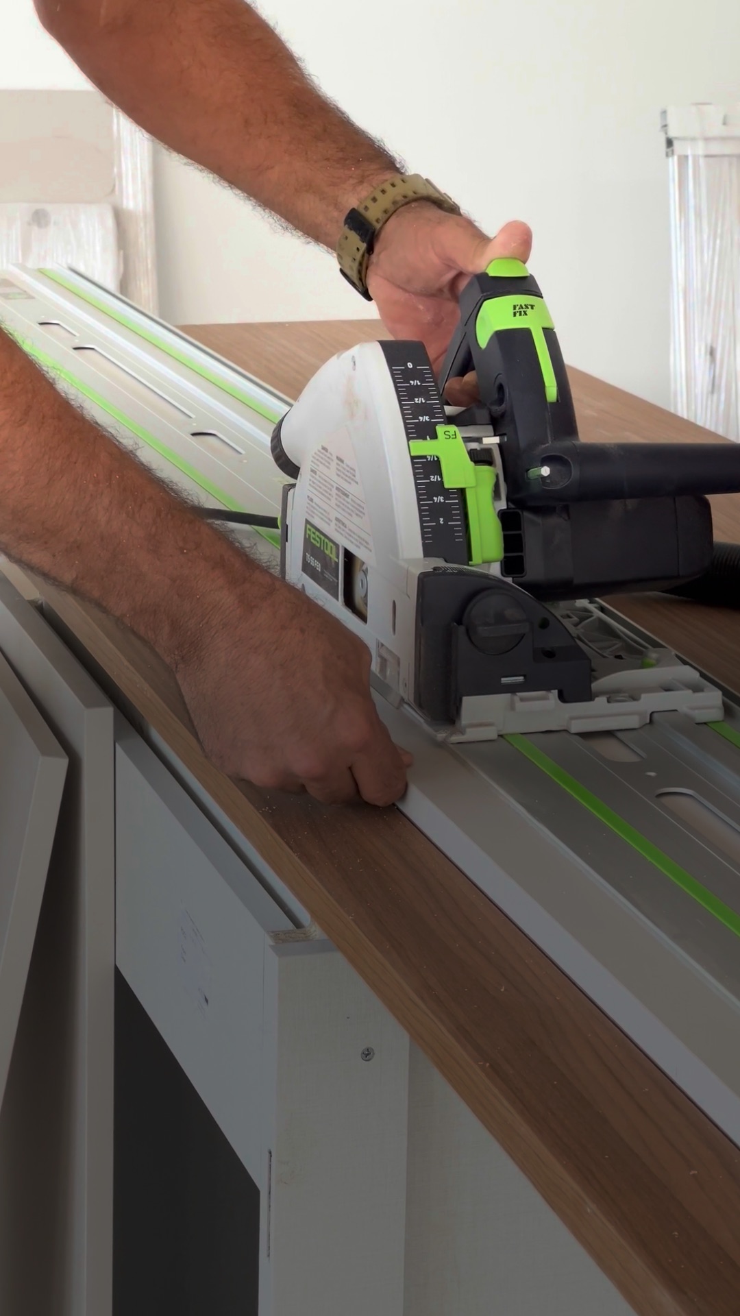 Cutting a walnut cabinetry panel on a track saw during custom kitchen fabrication in the Miami workshop.